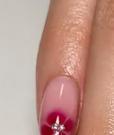 Blush pink BIAB nails with a berry floral accent nail and a tiny gem